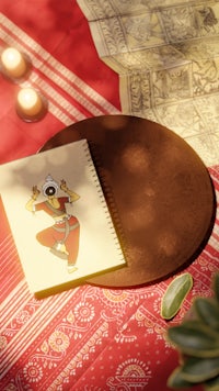 a notebook on a table next to a candle